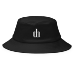 Close-up of a black bucket hat with a small white logo on the front that reads 'dlco' or similar, highlighting the fabric texture and stitching details.