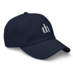 Close-up of a navy baseball cap with a small top button and part of white embroidered text visible on the front panel.