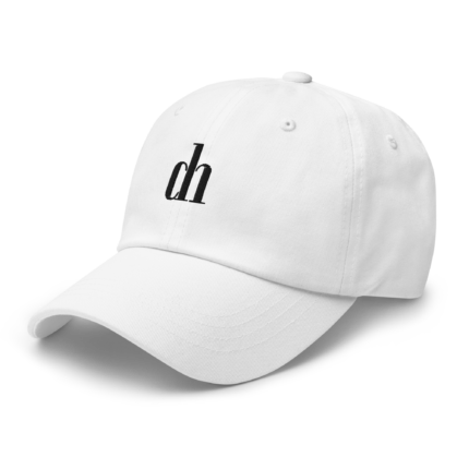 Close-up of a white baseball cap with stitched panels, viewed at an angle against a black background.