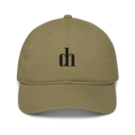 Khaki baseball cap close-up showing top button, stitched panels, and a partial black embroidery on the front.