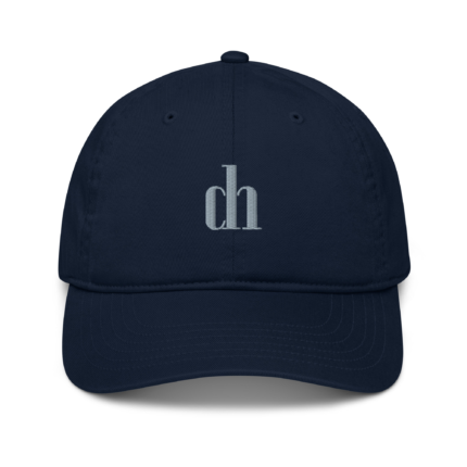 Navy baseball cap close-up, showing the top button and light gray 'ch' embroidery on the crown.